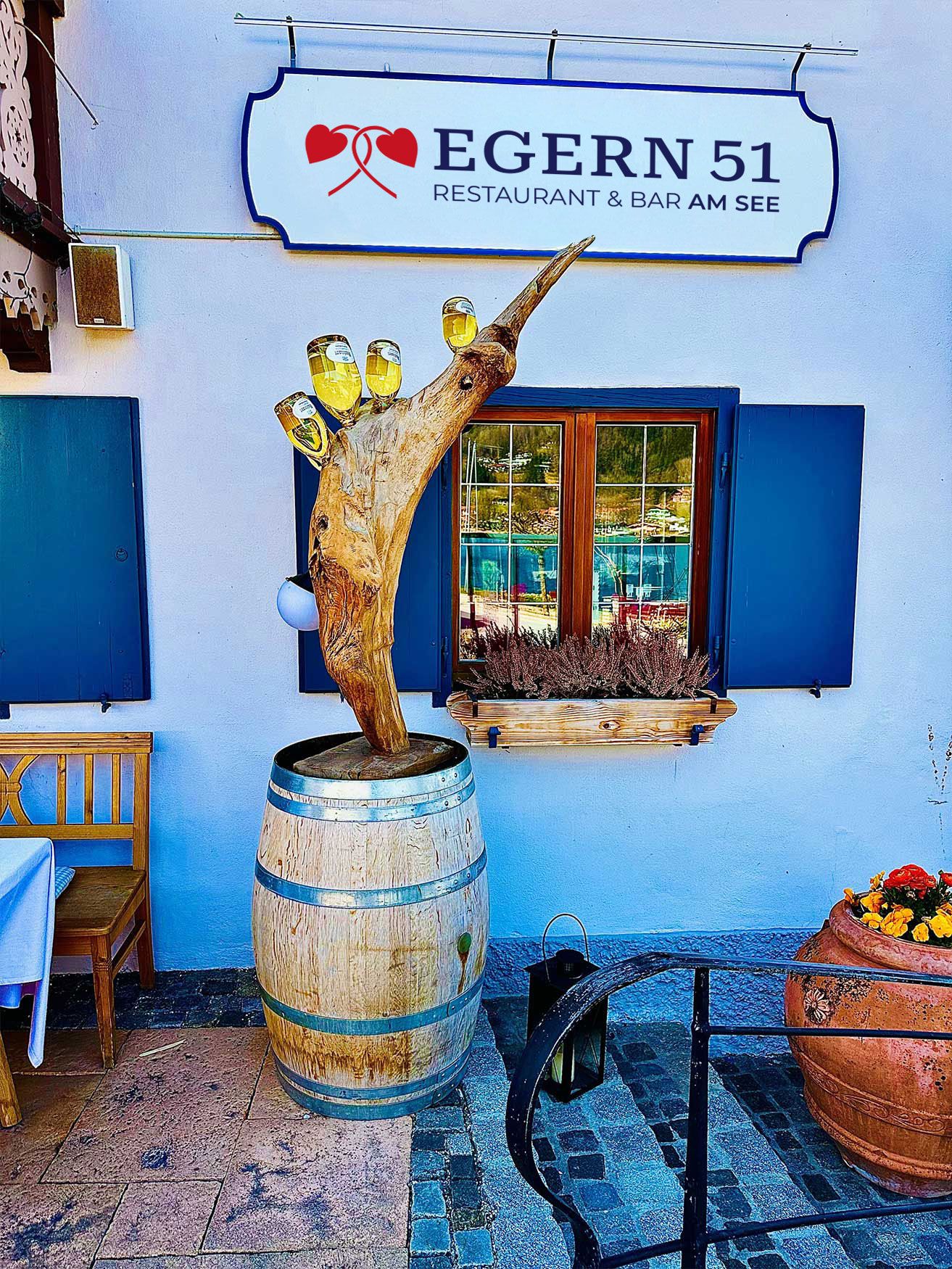 Ein Restaurant mit einem großen Holzfass vor dem Eingang, das eine einladende Atmosphäre schafft.