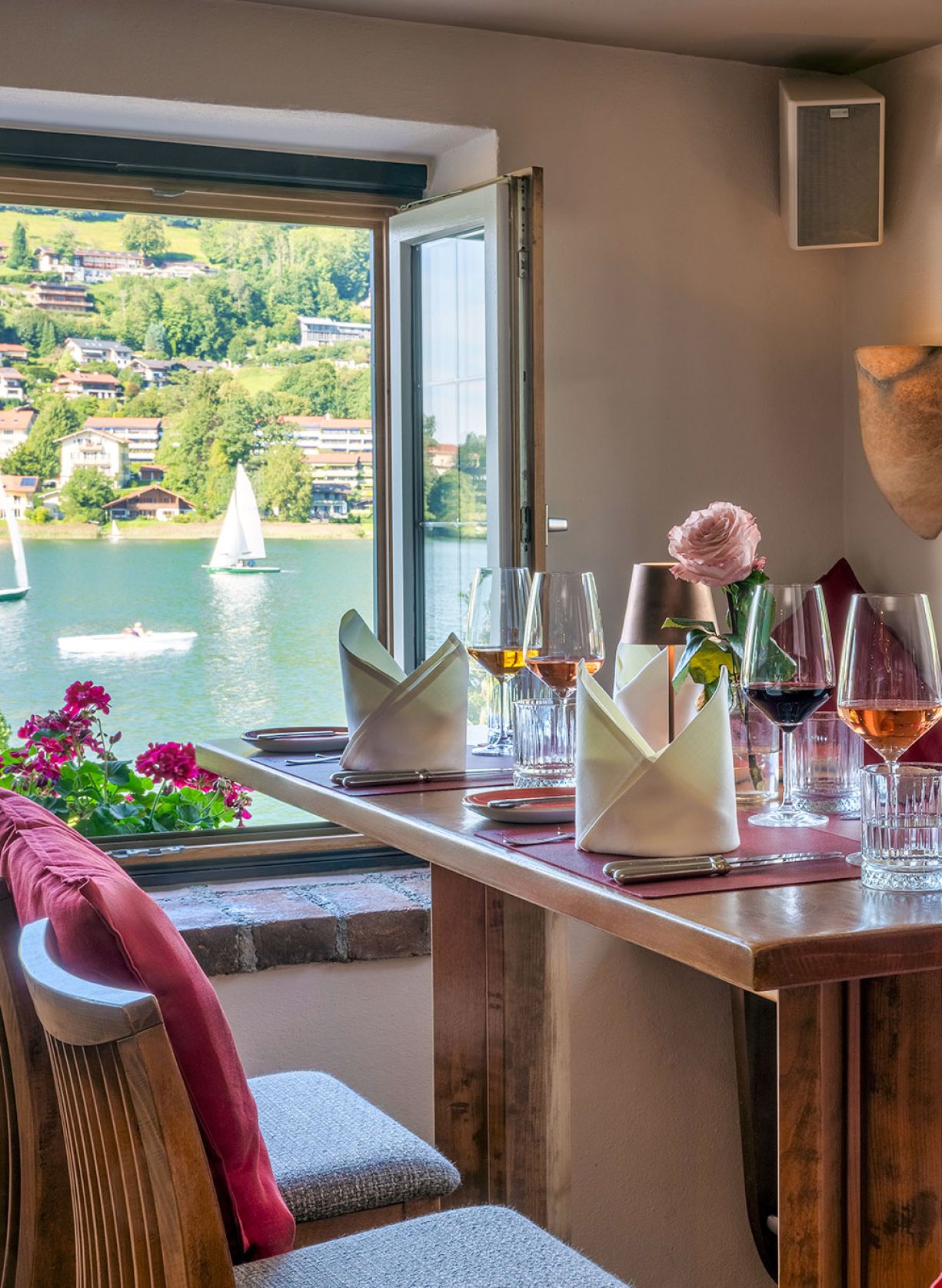 Ein kunstvoll angerichtetes Gourmetgericht mit rosa gebratenem Fleisch, knusprigen Chips, Püree und essbaren Blüten auf einem weißen Teller.